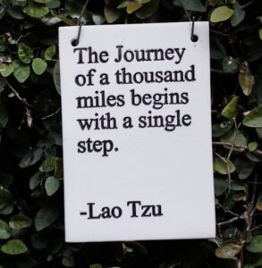 white and black quote board on green plants